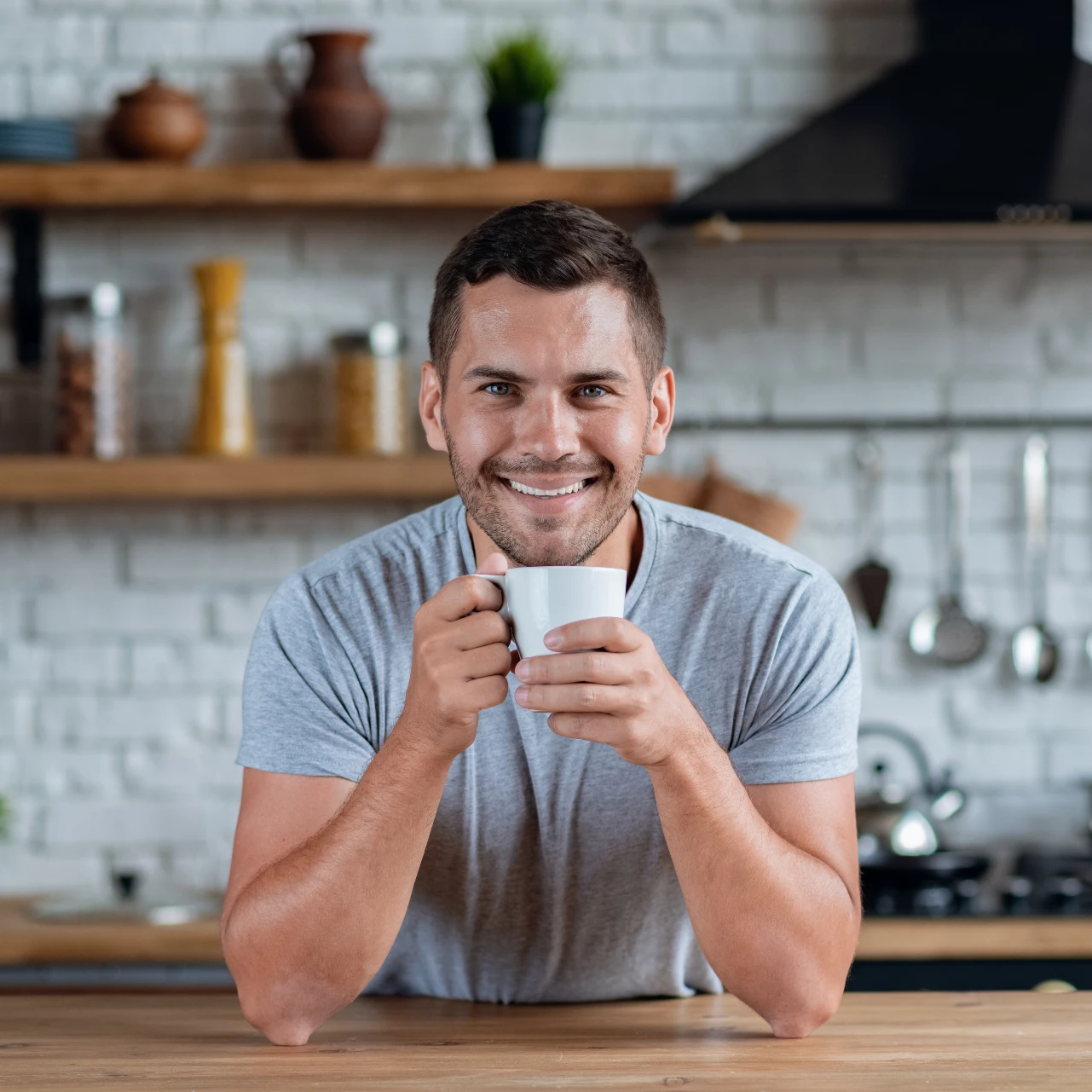 man smiling with cup of coffee after teeth whitening